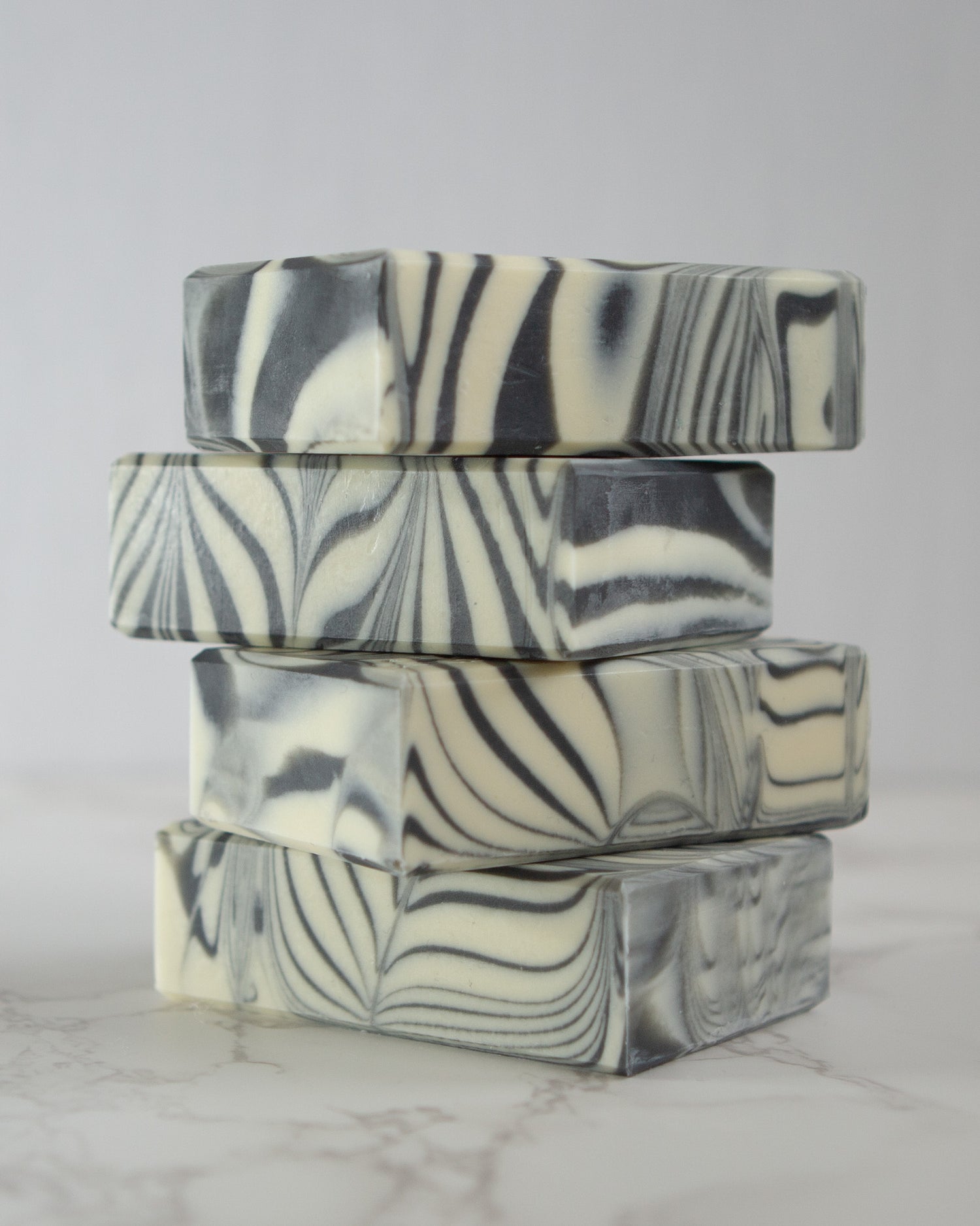 a stack of 4 bar handmade soaps with black and white swirl effect